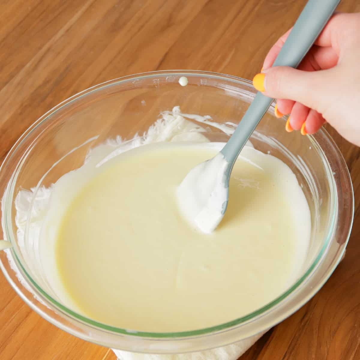 stirring coconut pudding in a glass bowl