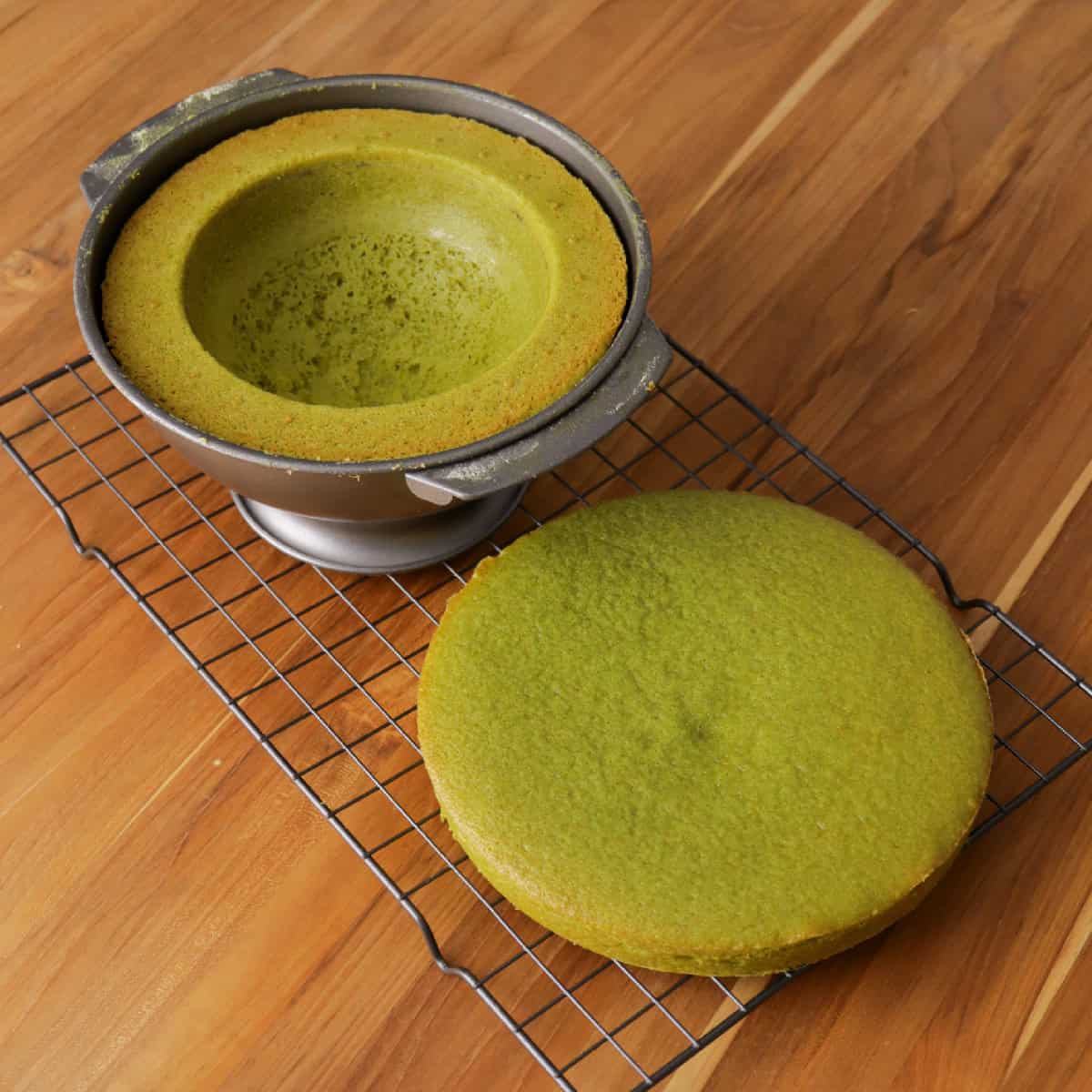 matcha cake in a dome pan and base layer on a wire rack