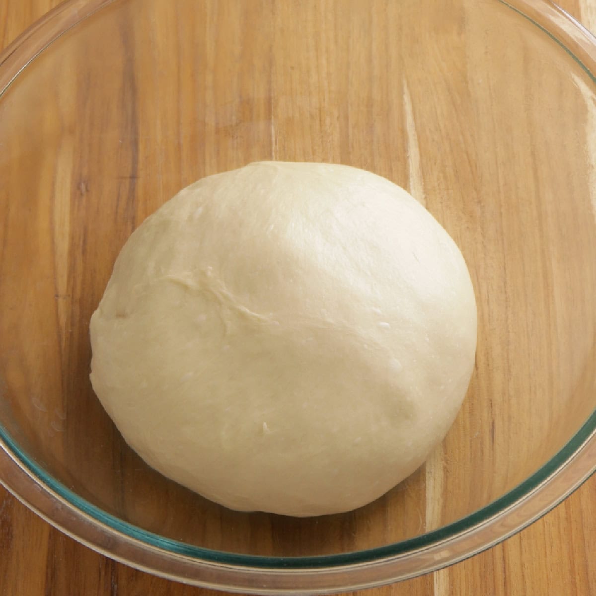 dough in a glass bowl, ready to be proofed