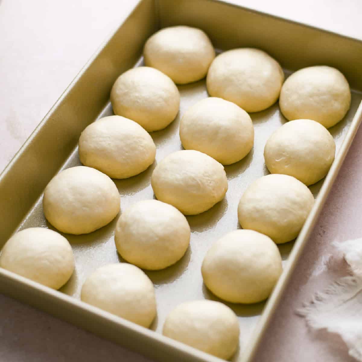 unproofed dough balls in a 9x13 pan